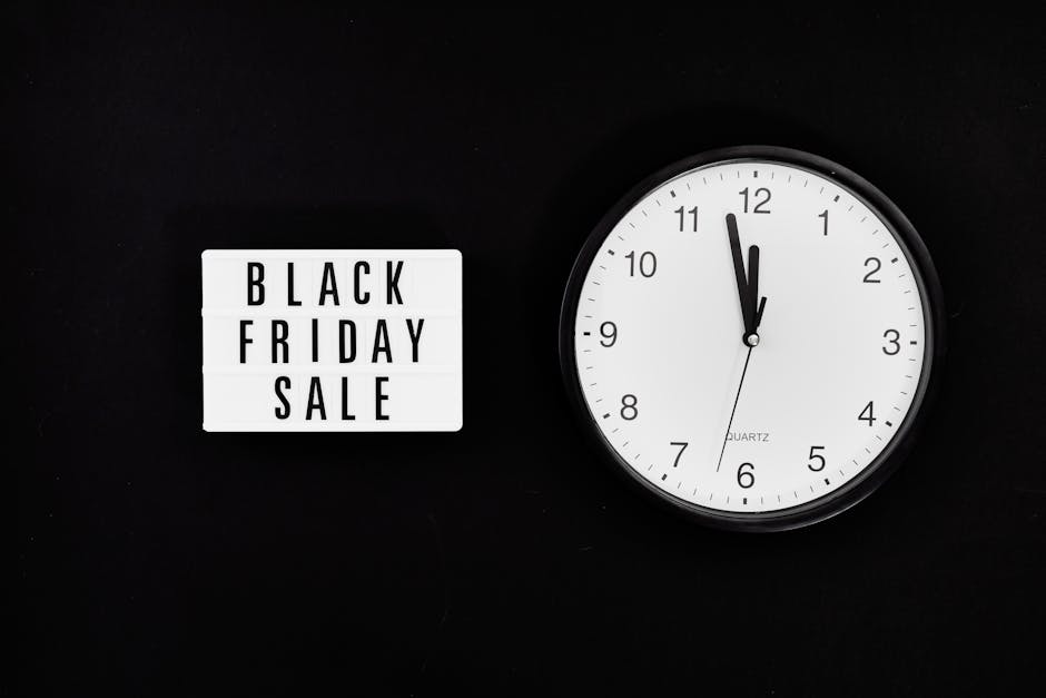A black background features a white lightbox sign displaying the words 'Black Friday Sale' in bold black letters on the left side. To the right of the sign, a round wall clock with a black frame and w